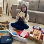 Criança em casa exibindo o Plano Letrar, material pedagógico do projeto Letrar Leitura Infantil